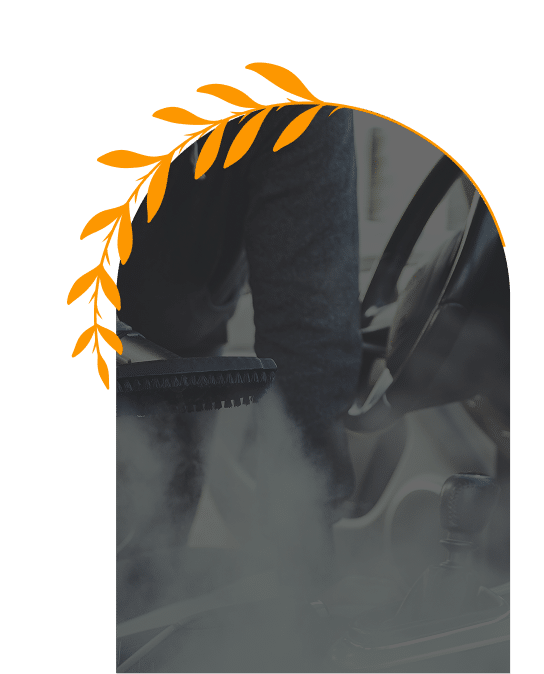 Nettoyage vapeur intérieur voiture : désinfection et brillance Détail d'un nettoyage vapeur intérieur de voiture : une brosse applique de la vapeur sur la console centrale près du levier de vitesse.